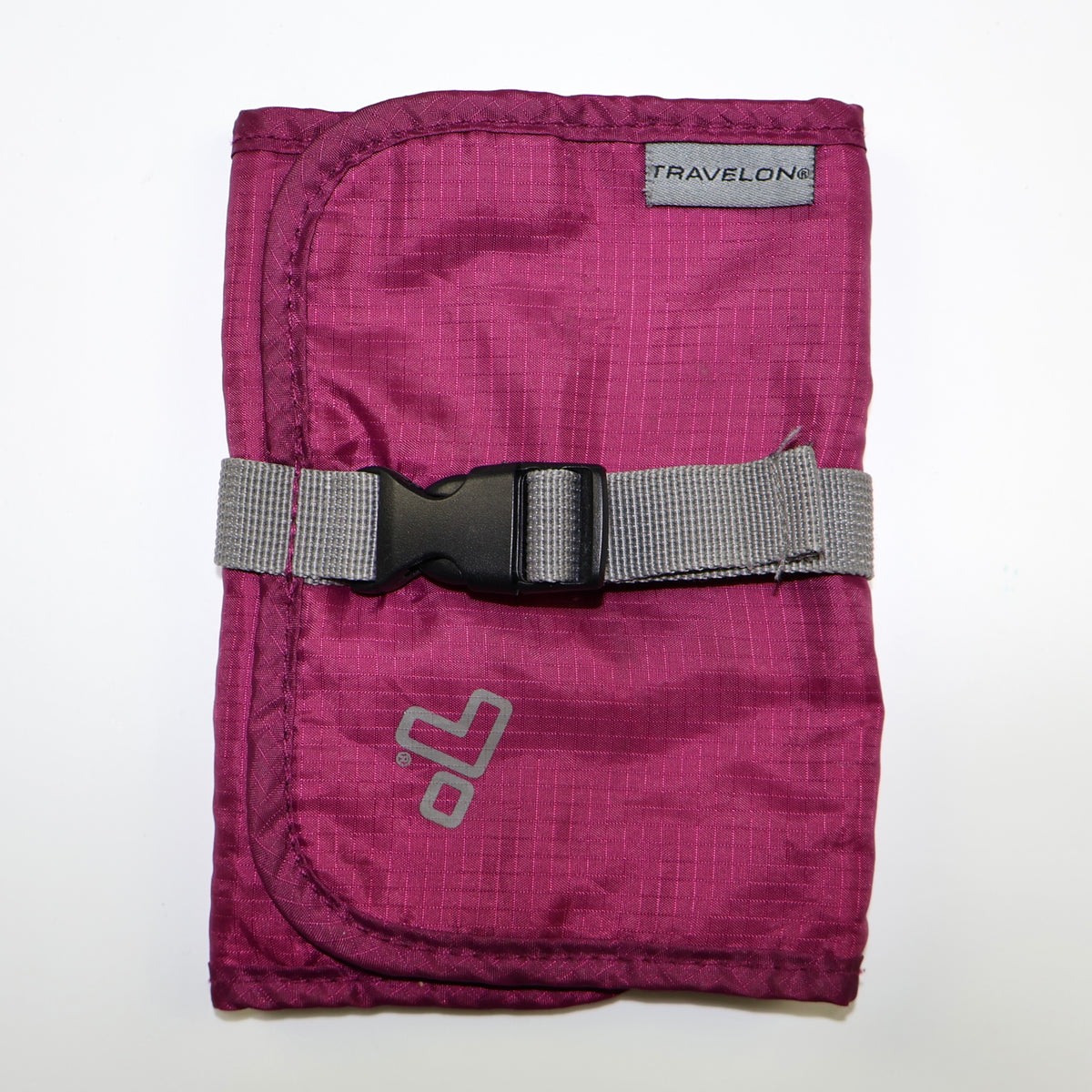 Estuche organizador Travelon color vino cerrado con correa y hebilla.