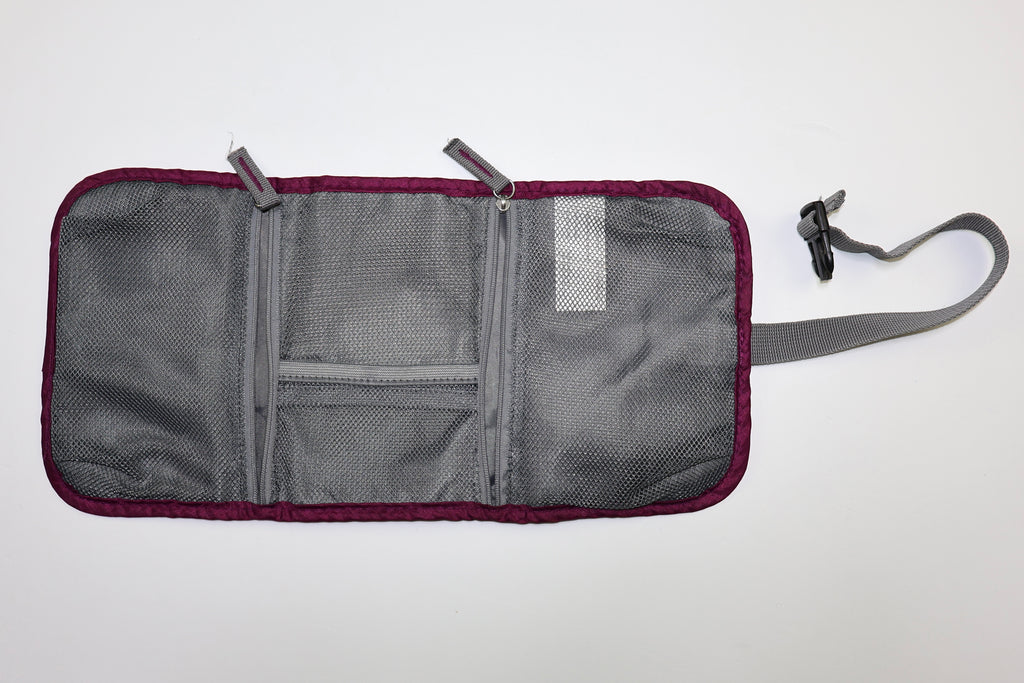 Estuche Travelon abierto con compartimentos interiores de malla y zipper.