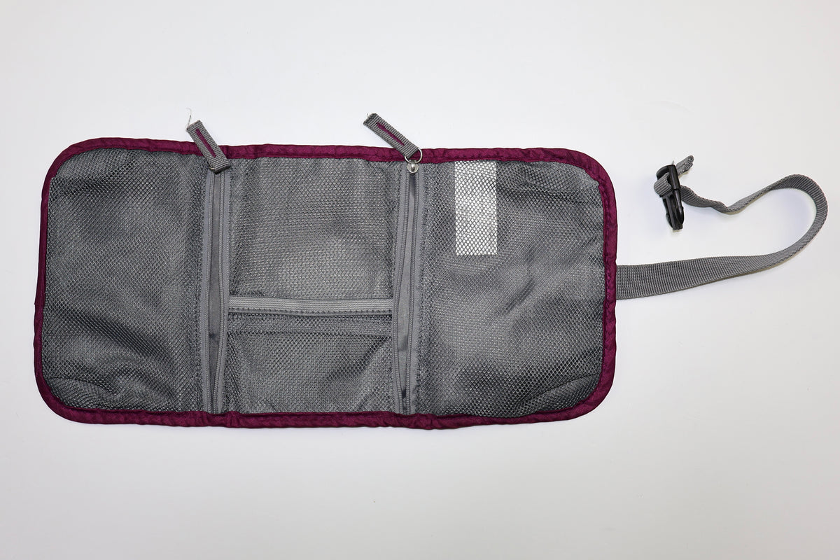 Estuche Travelon abierto con compartimentos interiores de malla y zipper.