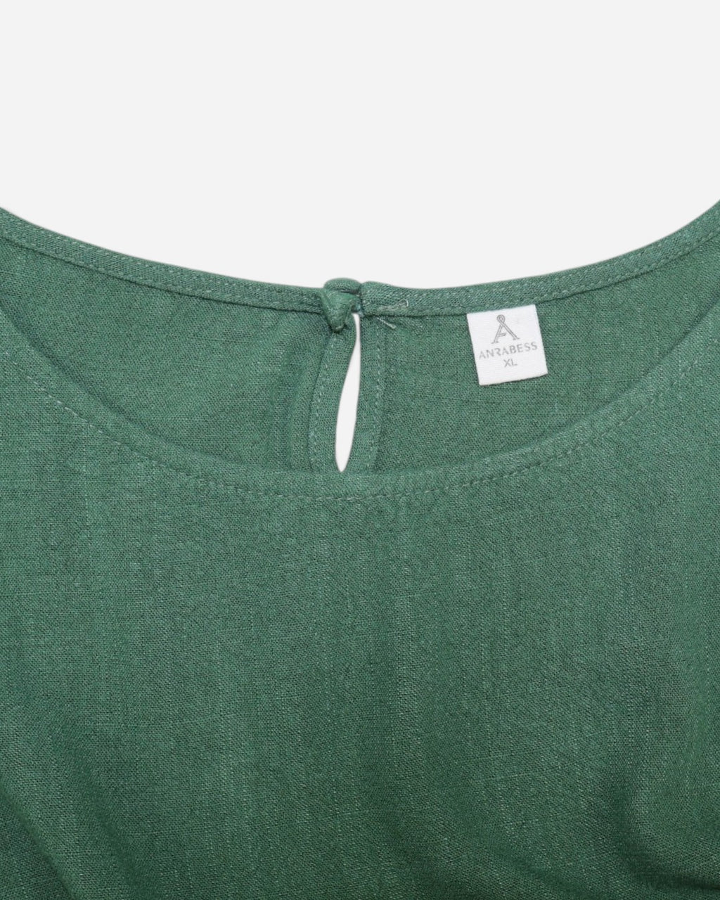 Etiqueta de composición de blusa verde con 70% rayón y 30% lino.