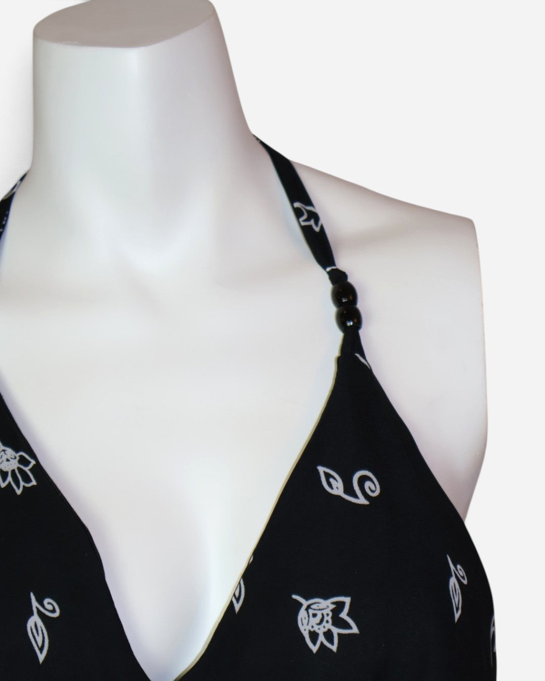Detalle de escote en V de vestido maxi negro estampado, ropa de segunda mano en RD