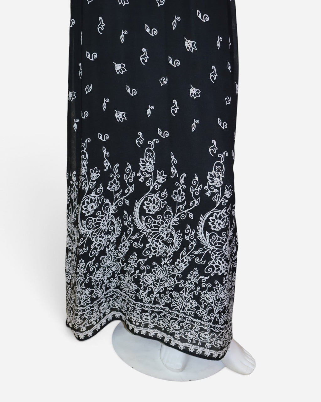 Detalle de estampado blanco en el ruedo de vestido maxi negro en The Reset