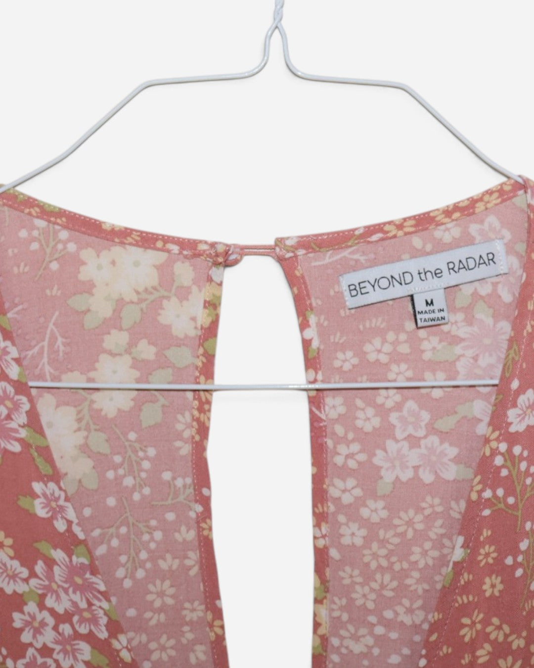 Etiqueta Beyond the Radar talla M en vestido floral rosado.