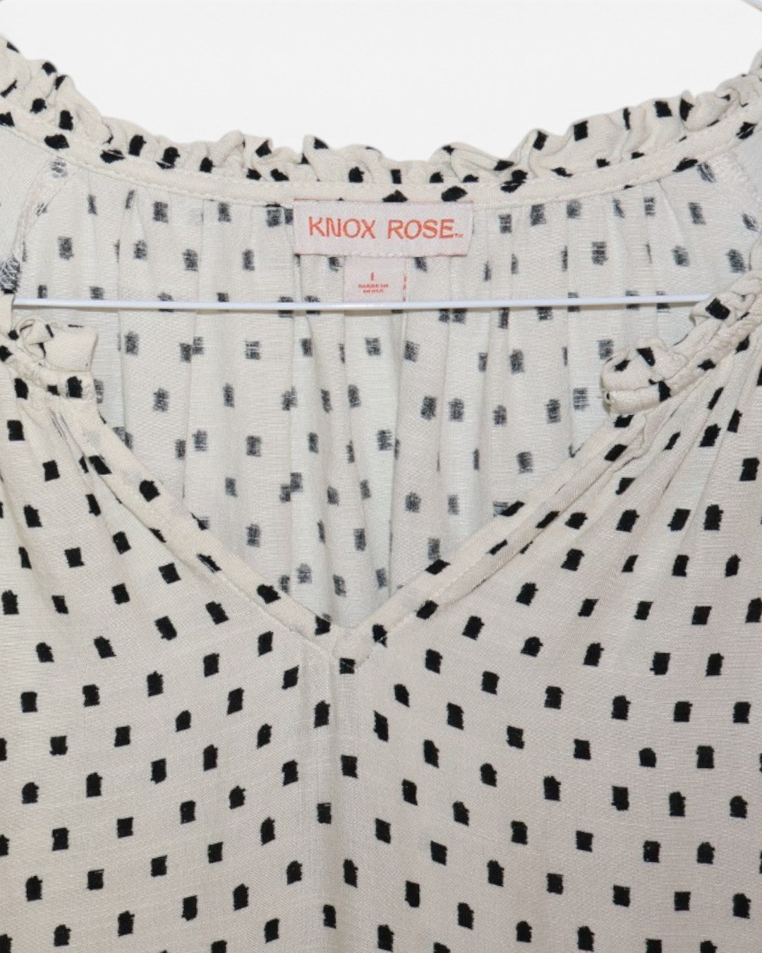 Etiqueta Knox Rose talla L en vestido crema con estampado negro.