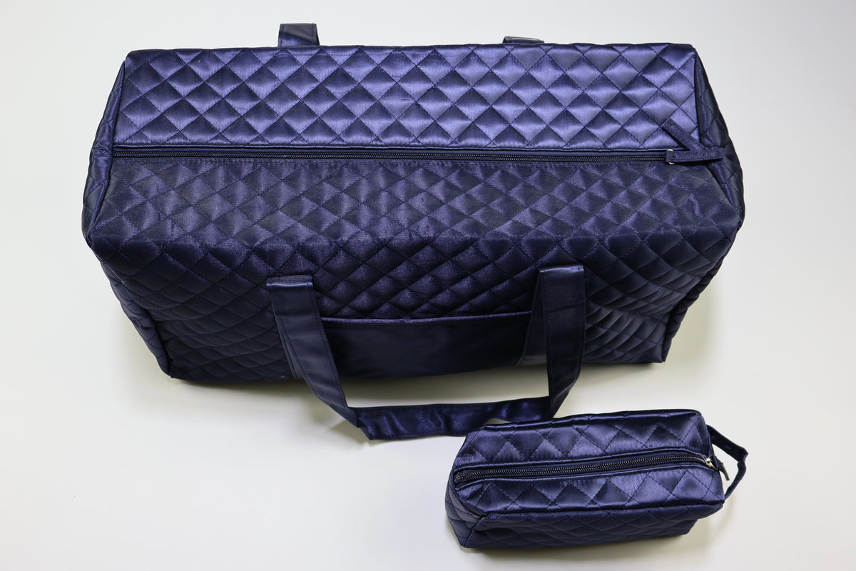 Bolso de viaje azul marino junto a neceser acolchado con referencia de tamaño.