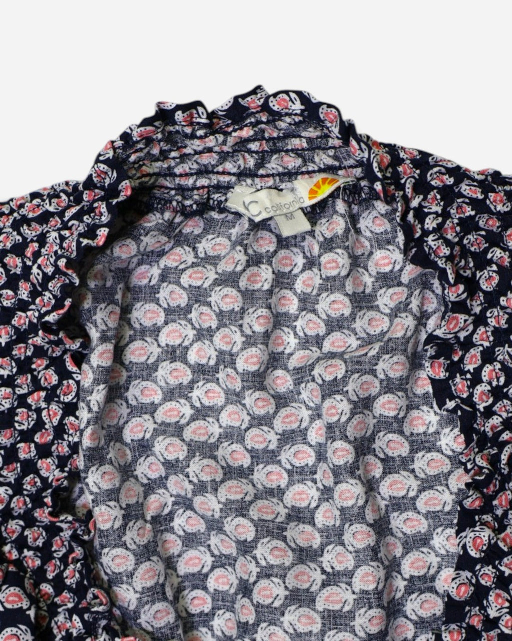 Detalle de escote en V con lazo de blusa estampada C&C California en The Reset